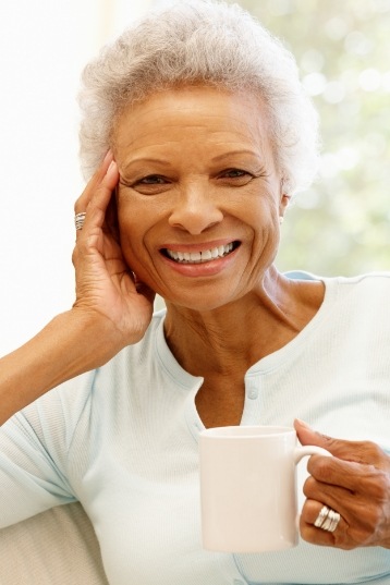 Smiling senior woman holding white coffee mug